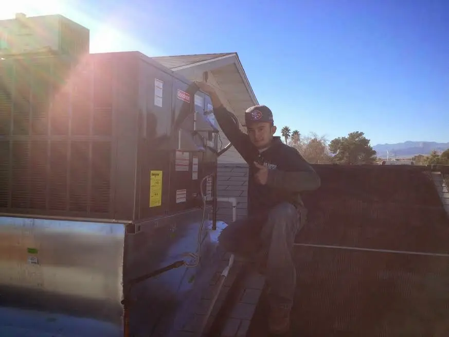 HVAC technician performing AC Tune-Up on a rooftop unit in Tyrone